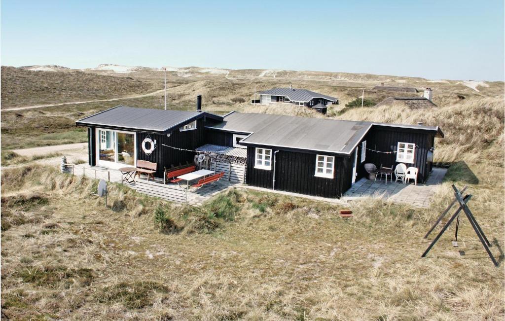 a black house in the middle of a field at Nice Home In Hvide Sande With House A Panoramic View in Havrvig