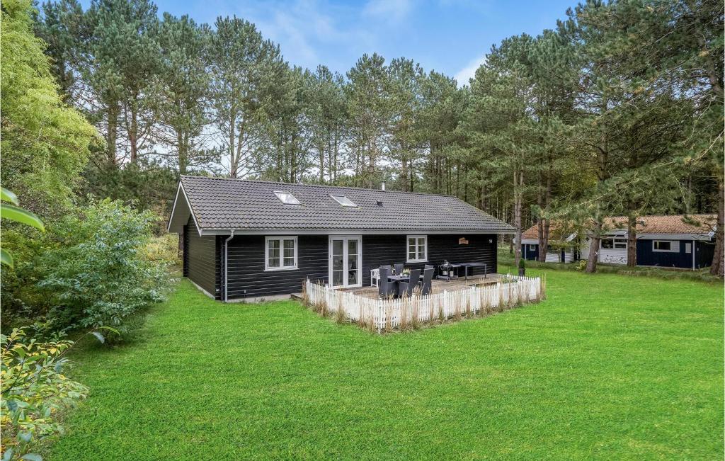 a black cabin in the middle of a yard at 3 Bedroom Gorgeous Home In Rdby in Rødbyhavn