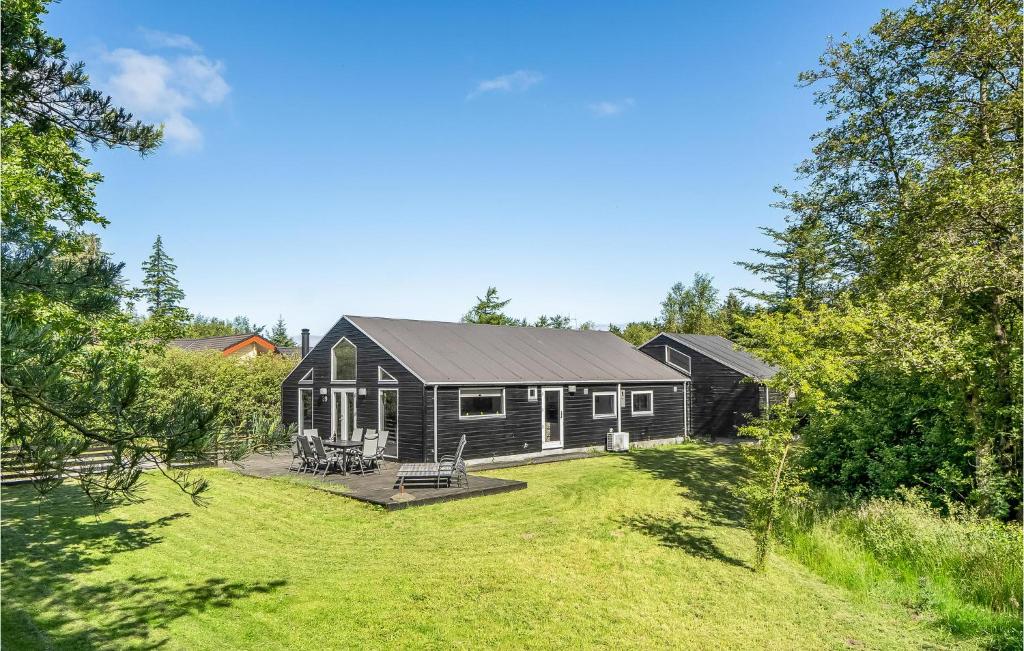 a black house with a yard in front of it at Nice Home In Oksbl With Sauna in Ovtrup
