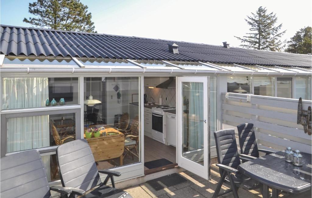 a conservatory with a table and chairs on a patio at Apartment Vejers Sydstrand I-937 in Vejers Strand