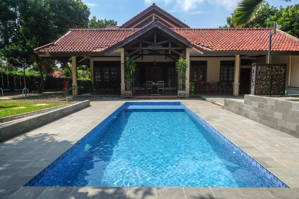 a swimming pool in front of a house at SAREH VILLA by The Lavana in Semarang