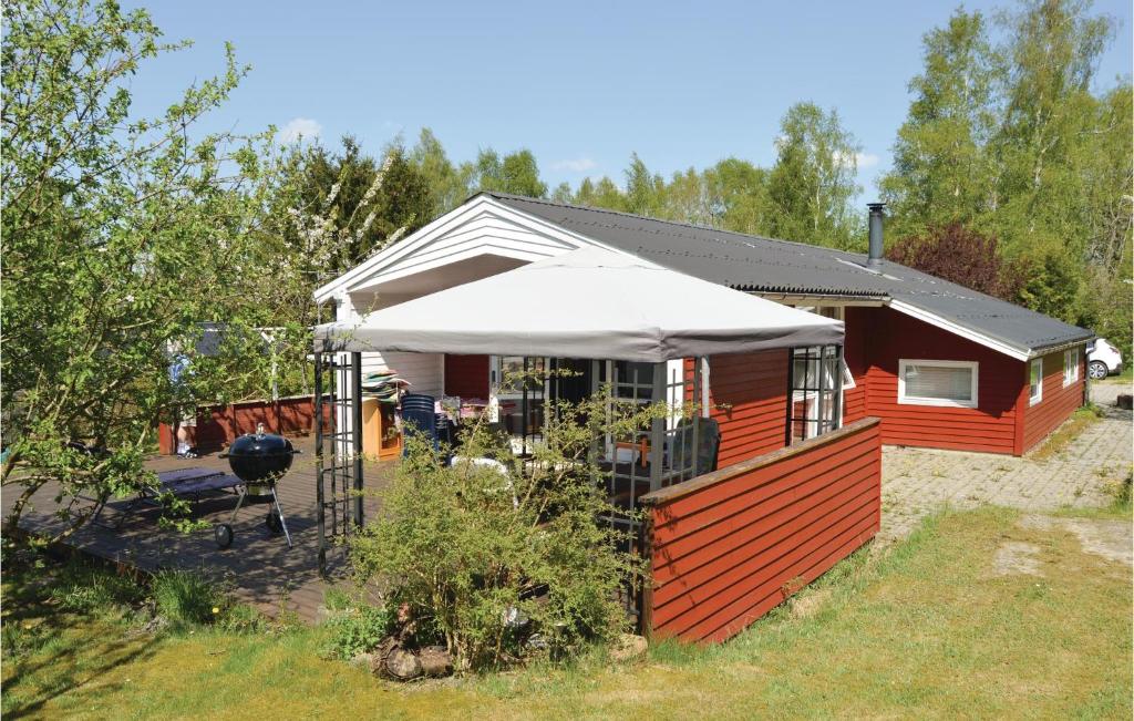 a red house with a white roof and a grill at 3 Bedroom Cozy Home In Fårvang in Fårvang