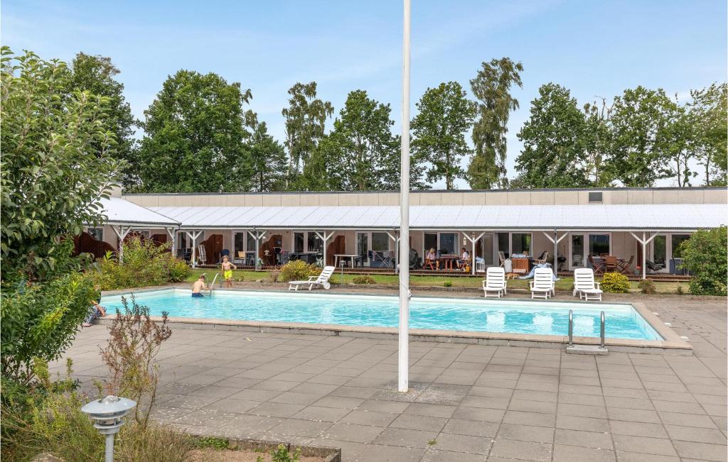 a swimming pool with chairs and a building at Gorgeous Apartment In Nex With Kitchen in Neksø