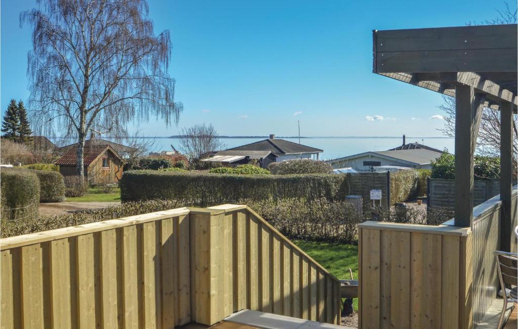a wooden fence in front of a yard with houses at Three-Bedroom Holiday Home In Hejls in Hejls