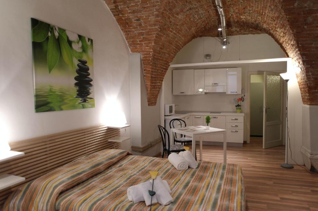una camera con letto e tavolo e una cucina di YOURHOMEINLUCCA Le Volte a Lucca