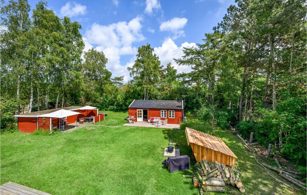 una pequeña cabaña roja en medio de un patio en Cozy Home In Eskebjerg With Kitchen en Eskebjerg