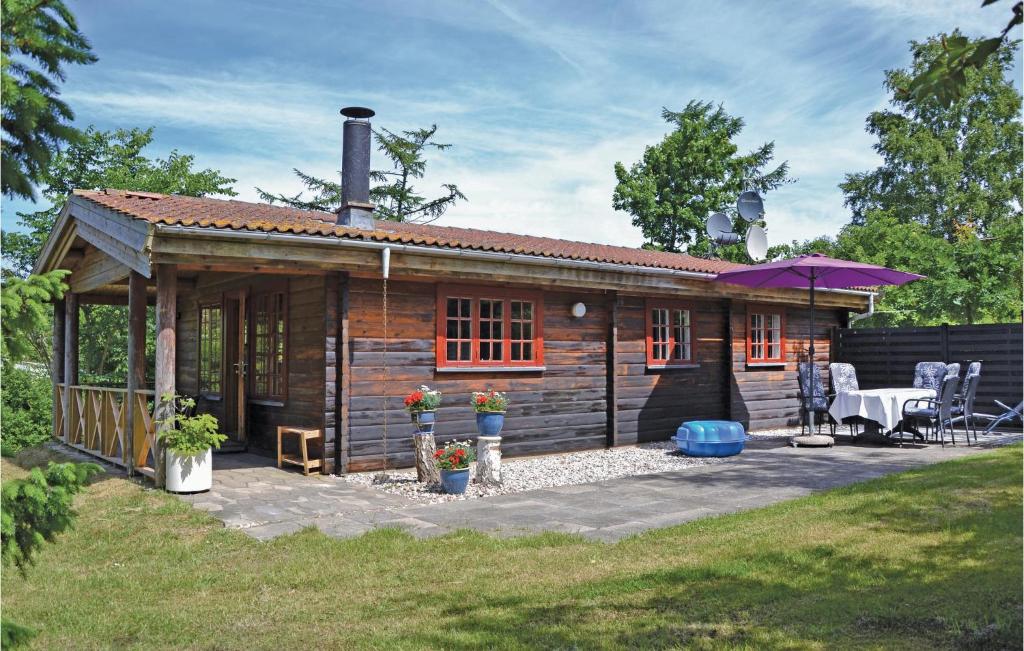 a small wooden cabin with a patio and a table at Nice Home In Jgerspris With Wifi in Bakkegårde