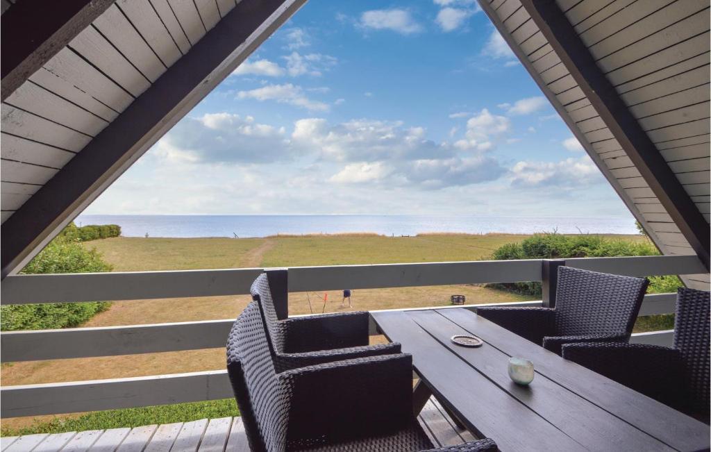uma mesa e cadeiras num alpendre com vista para o oceano em Pet Friendly Home In Haderslev With Wifi em Årø