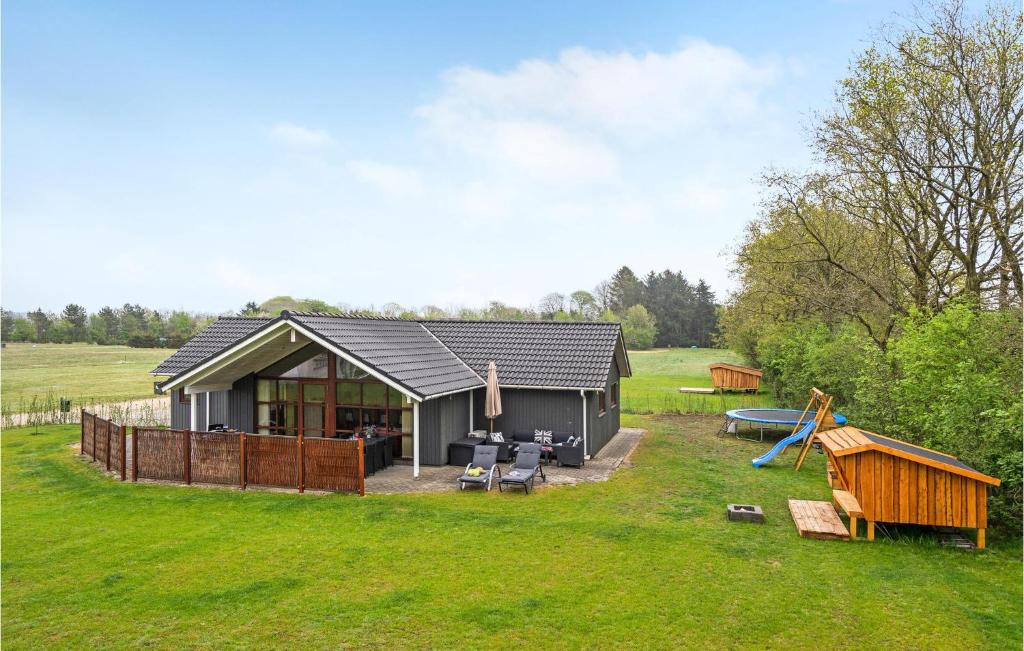 a small house in a field with a playground at Awesome Home In Ansager With Wifi in Ansager