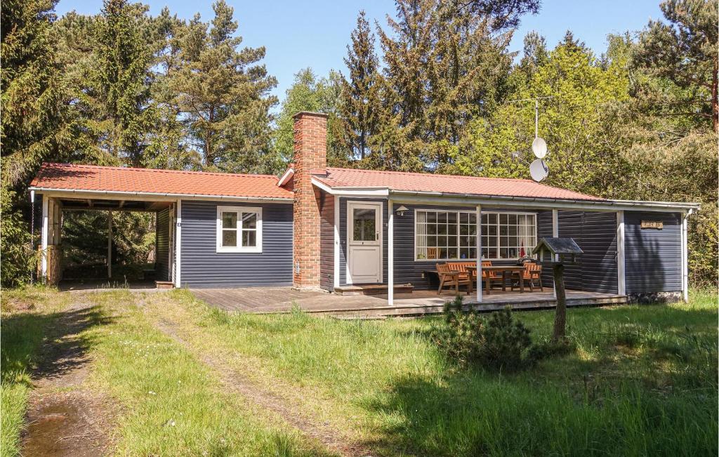 a small blue house with a porch and a patio at 4 Bedroom Lovely Home In Nexø in Neksø