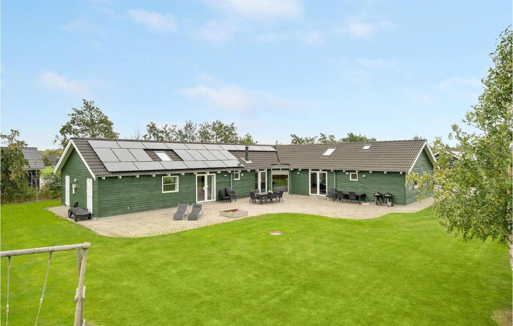 une maison verte avec une terrasse et une cour dans l'établissement Lovely Home In Idestrup With Sauna, à Bøtø By