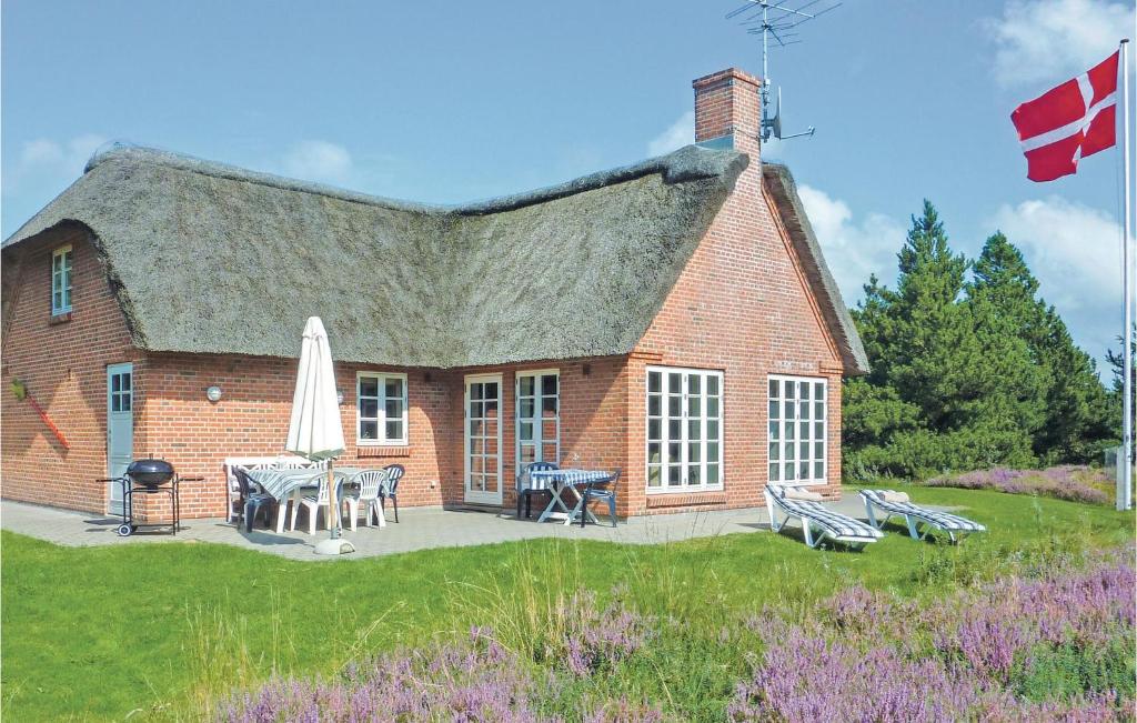 a red brick house with a patio and a flag at Holiday Home Præstekraven Rømø in Rømø Kirkeby