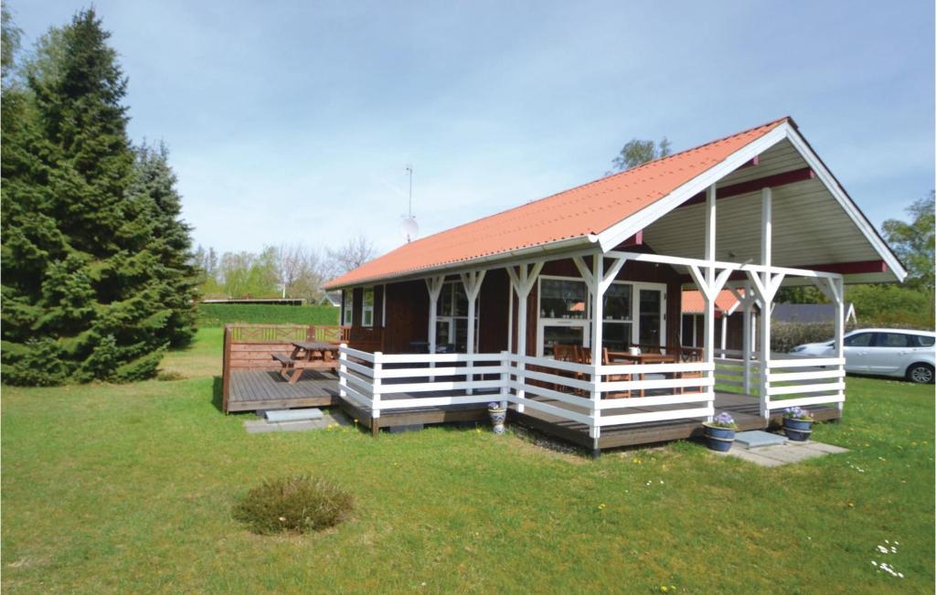 una pequeña casa con techo rojo en un patio en Pet Friendly Home In rsted With Kitchen en Kare