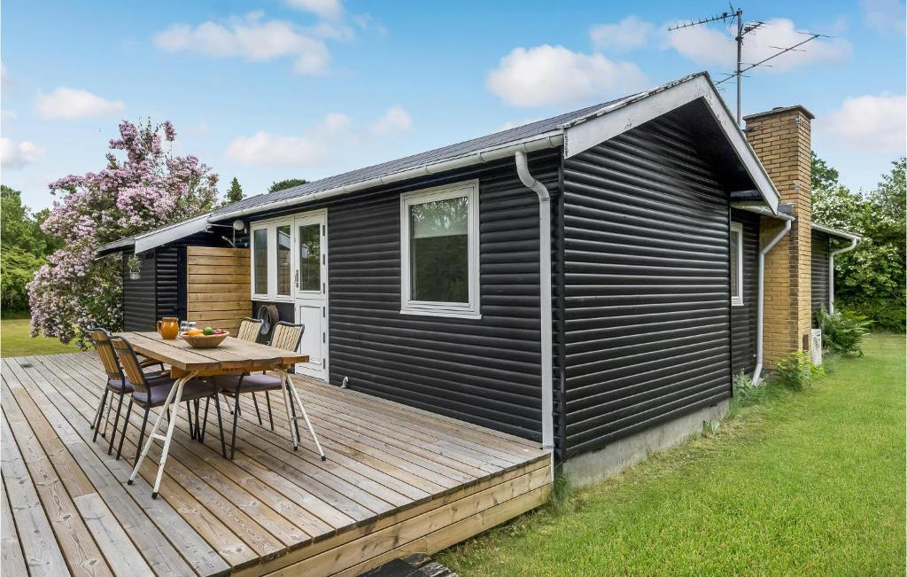 a black tiny house with a wooden deck at Holiday Home Vejby With Fireplace I in Vejby