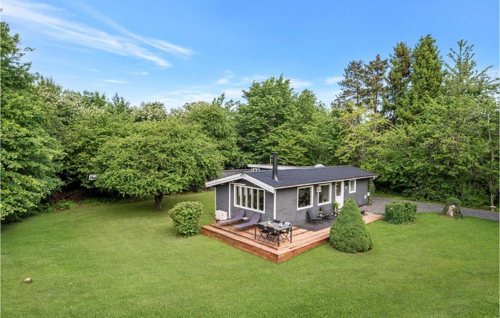 a small house with a deck in a yard at Two-Bedroom Holiday Home In Jagerspris in Jægerspris