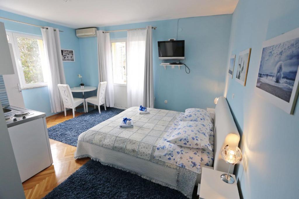 Dormitorio azul con cama y mesa en Apartments & Rooms Andrea, en Zadar