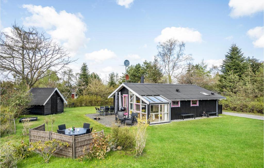 a black house in the middle of a yard at Holiday Home Gøgeurtvej Væggerløse X in Marielyst