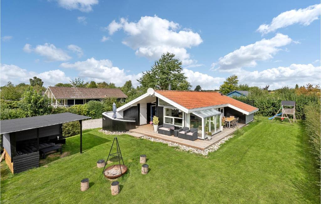 a small house with an orange roof on a yard at Beautiful Home In Juelsminde With 4 Bedrooms, Wifi And Indoor Swimming Pool in Sønderby