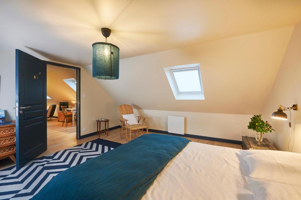 een slaapkamer met een groot bed en een spiegel bij La vigie d'Héloïse, appartement de l'Aod in Lampaul