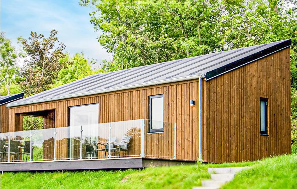 een houten huis met een metalen dak bij Lovely Home In Brkop With Outdoor Swimming Pool in Børkop