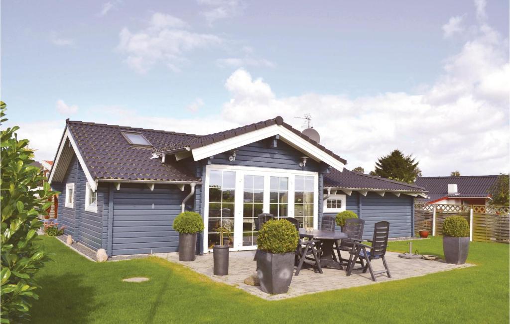 ein blaues Haus mit einem Tisch und Stühlen im Hof in der Unterkunft Stunning Home In Rnde With Kitchen in Rønde