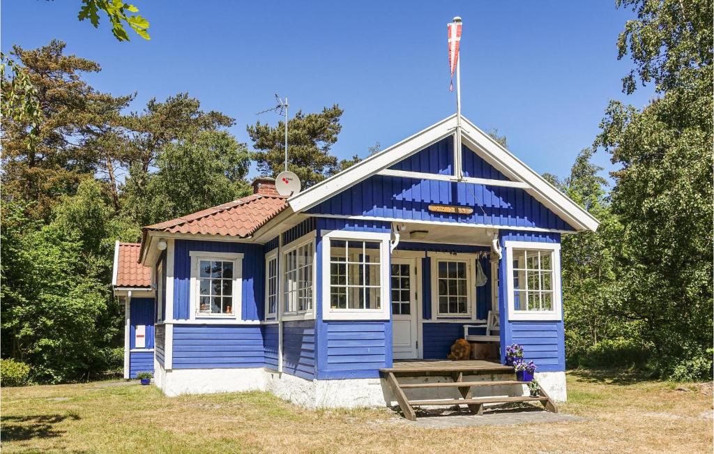 ein blaues Haus mit einer Bank davor in der Unterkunft Beautiful Home In Nexø With Sauna in Neksø