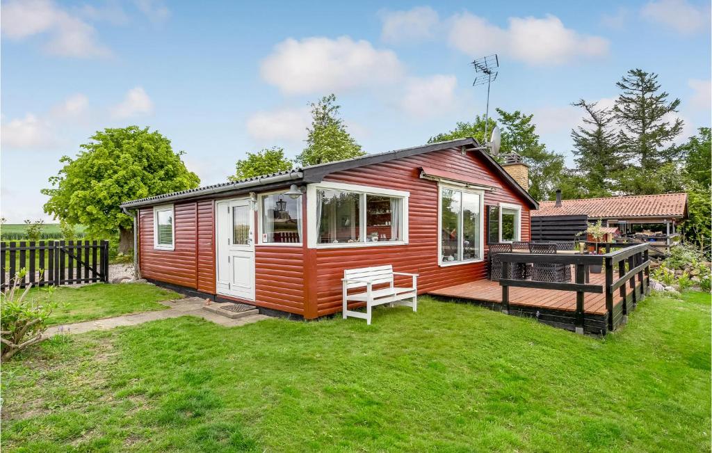 une petite maison rouge avec une terrasse dans l'établissement 2 Bedroom Amazing Home In Sydals, à Østerby