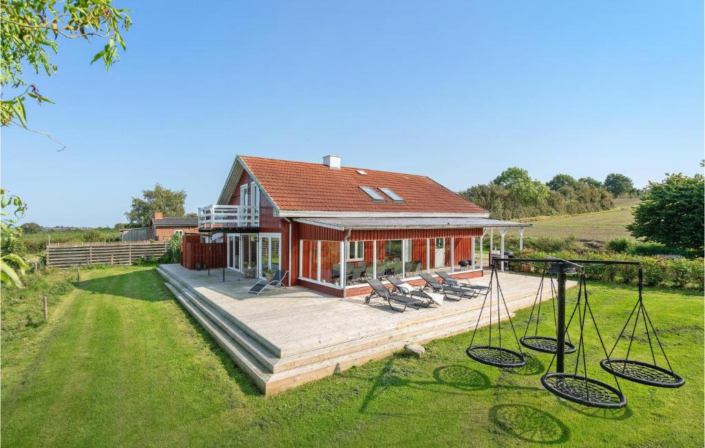 a house with a large deck with chairs on it at Pet Friendly Home In Christiansfeld With Sauna in Christiansfeld