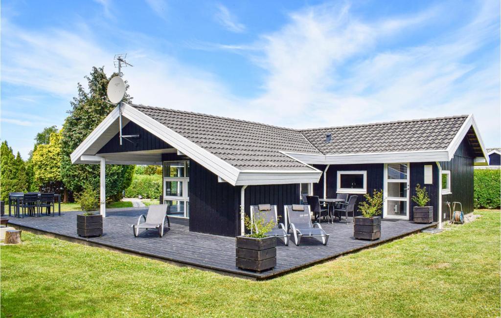 a blue house with a deck and chairs at 3 Bedroom Nice Home In Humble in Humble