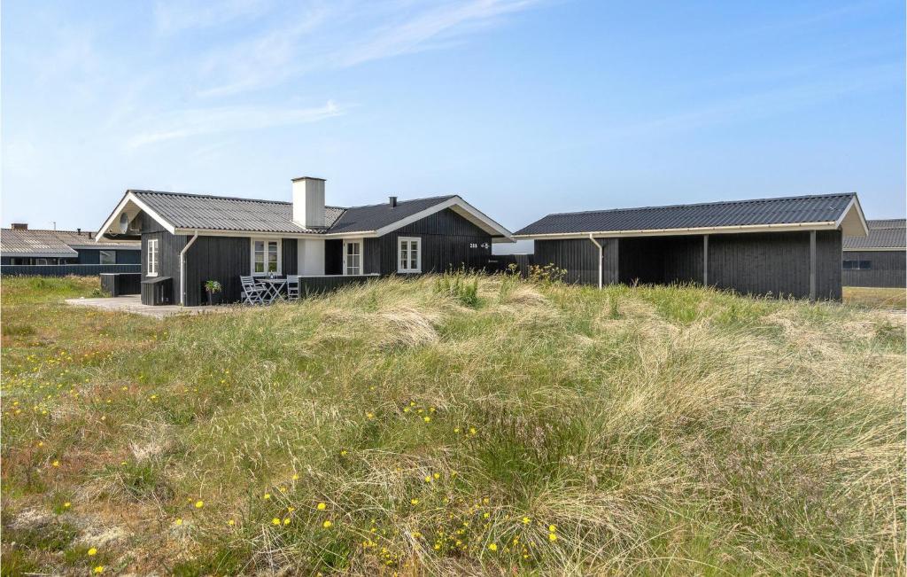 a house on top of a grassy hill at Holiday Home Arvidvej Hvide Sande Xii in Bjerregård