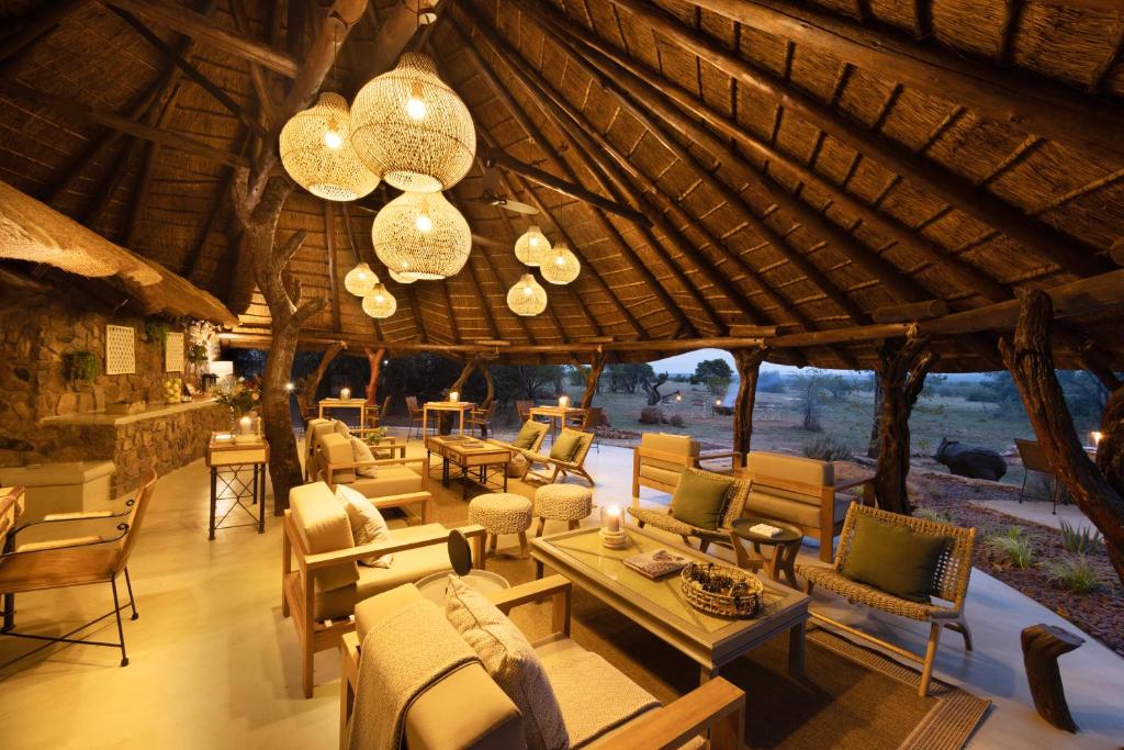Großes Zimmer mit Stühlen, Tischen und Kronleuchtern in der Unterkunft Kwafubesi Tented Safari Camp in Mabula