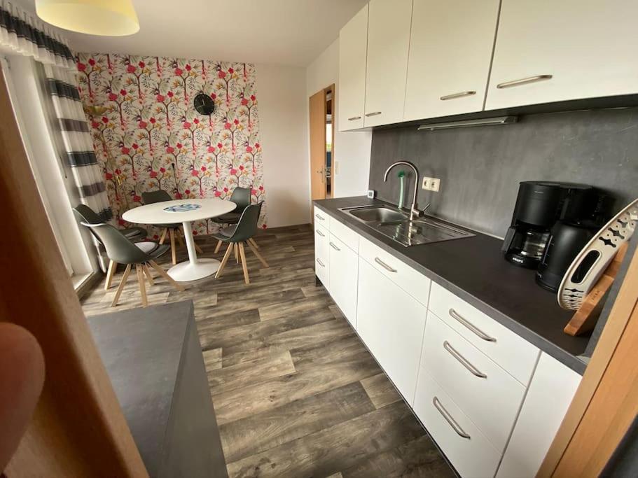 a kitchen with a sink and a table in a room at Haus Eierhof in Papenburg