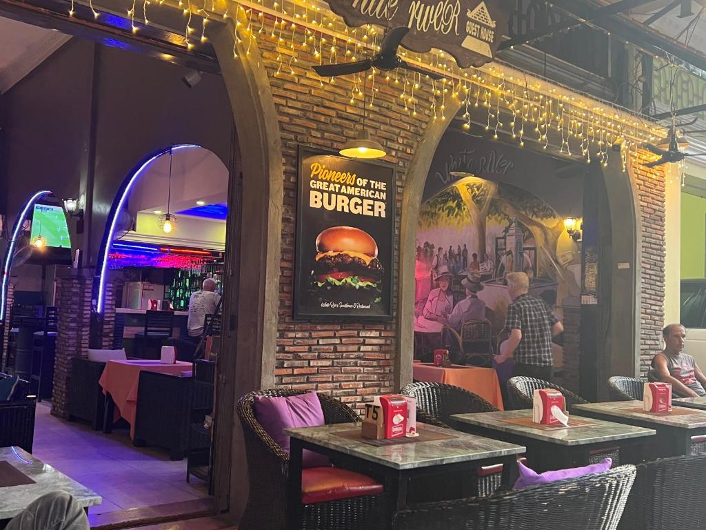 a restaurant with a burger sign on a brick wall at White River guesthouse in Phnom Penh