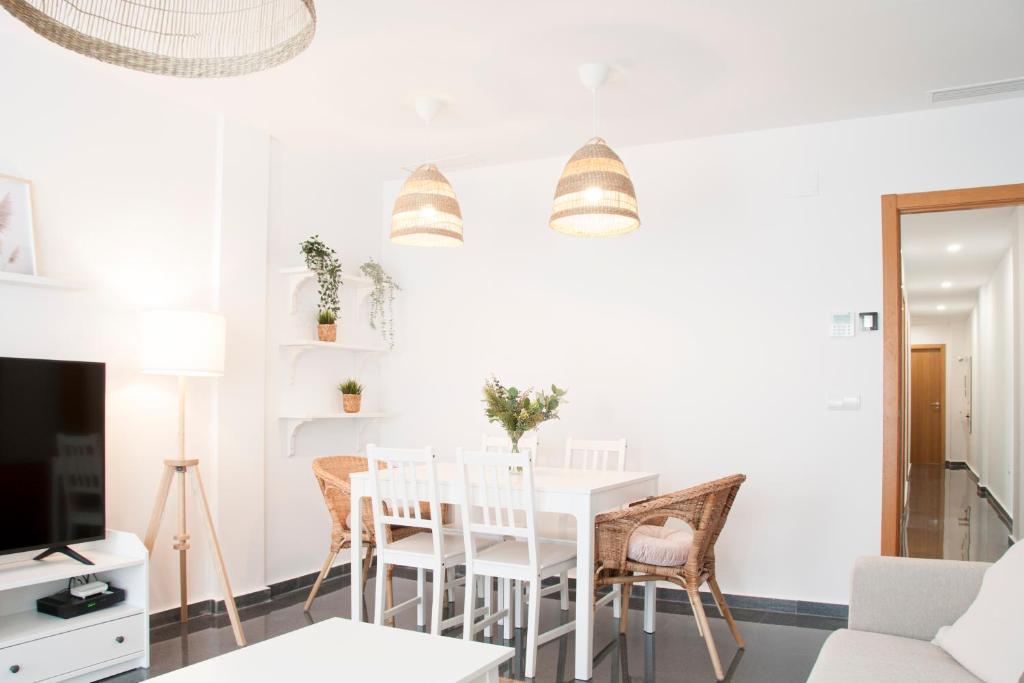 Felipe Antón Suites في موتيكْتْساميل: غرفة معيشة بيضاء مع طاولة وكراسي بيضاء