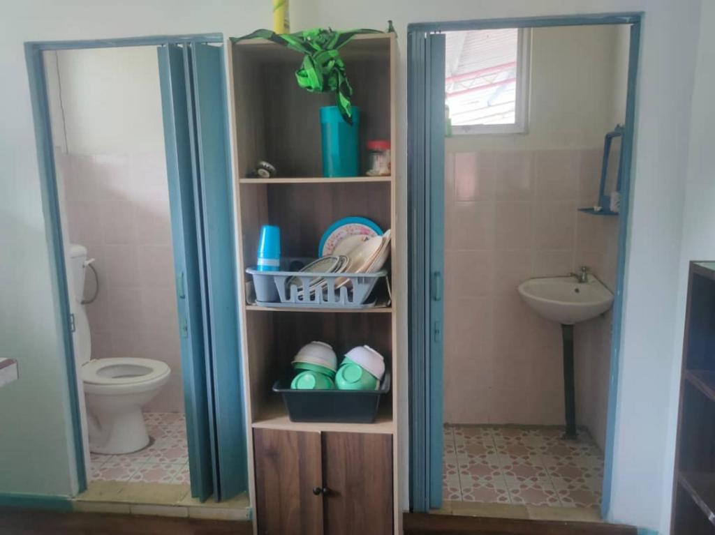 a small bathroom with a toilet and a sink at MAK Homstay upstairs in Kundasang
