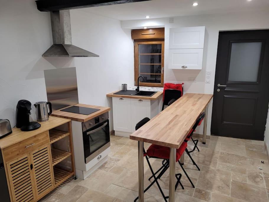 a kitchen with a wooden table and a counter top at maison des vendangeurs in Villarzel-Cabardès