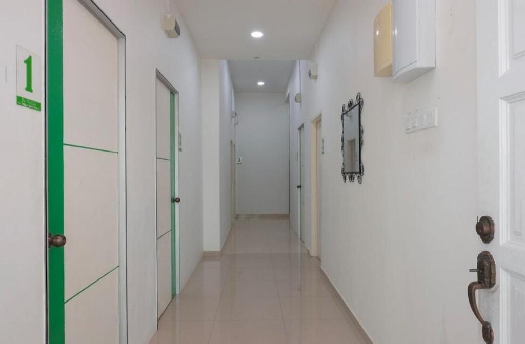 einen Korridor eines Krankenhauses mit weißen Wänden und Türen in der Unterkunft DLAYARAN VILLA GUEST HOUSE in Kuala Rompin