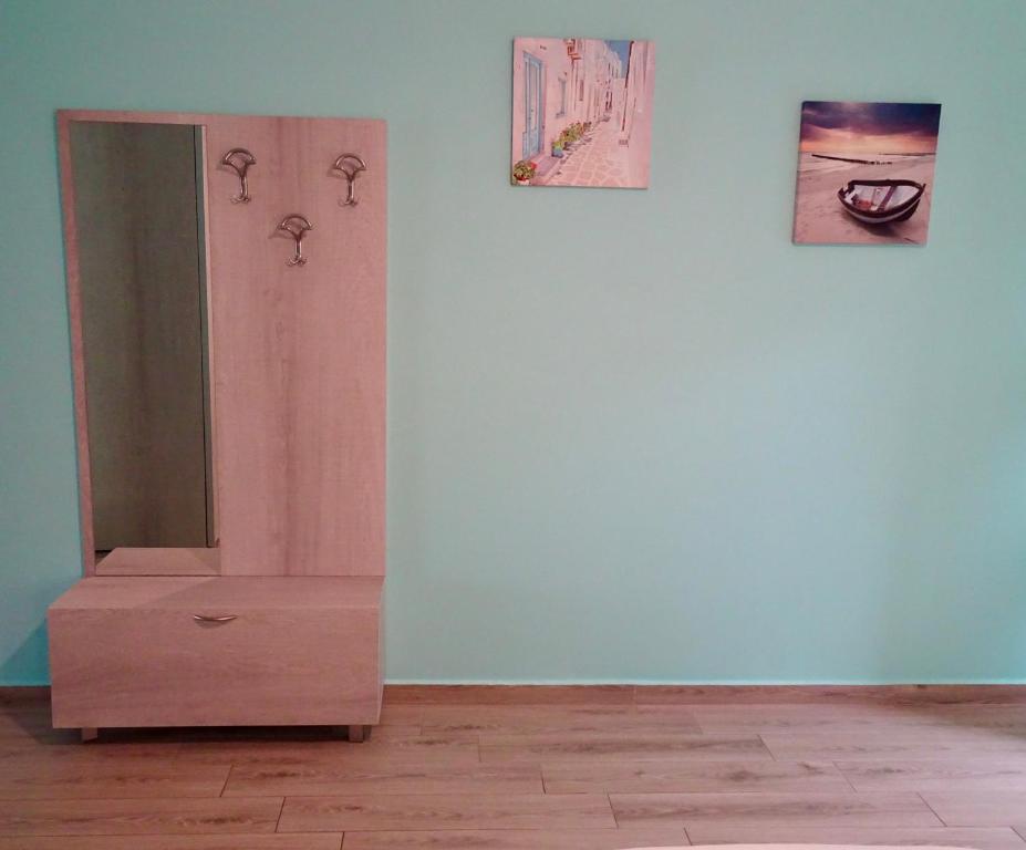 komodę w pokoju z dwoma zdjęciami na ścianie w obiekcie Faros apartment w mieście Sfakia