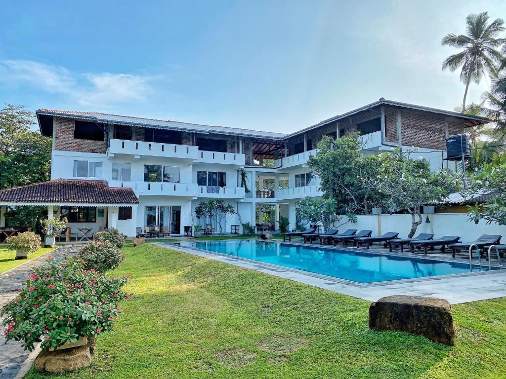 einen Blick nach außen auf ein Hotel mit Pool in der Unterkunft Villa Kaya Guest House in Hikkaduwa