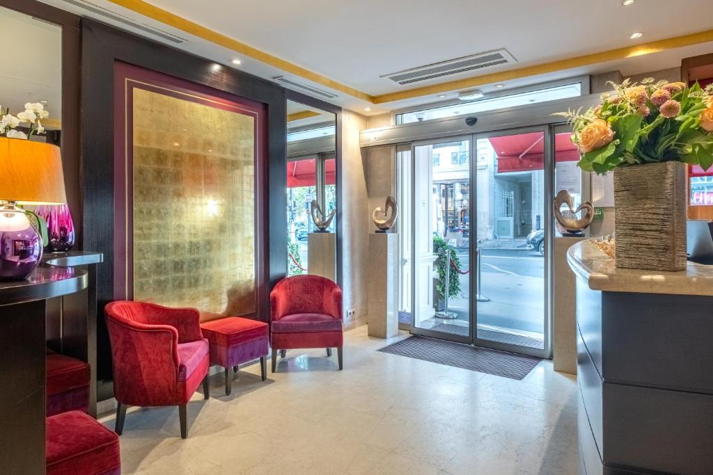 a lobby with red chairs and a bar at Courcelles Etoile in Paris