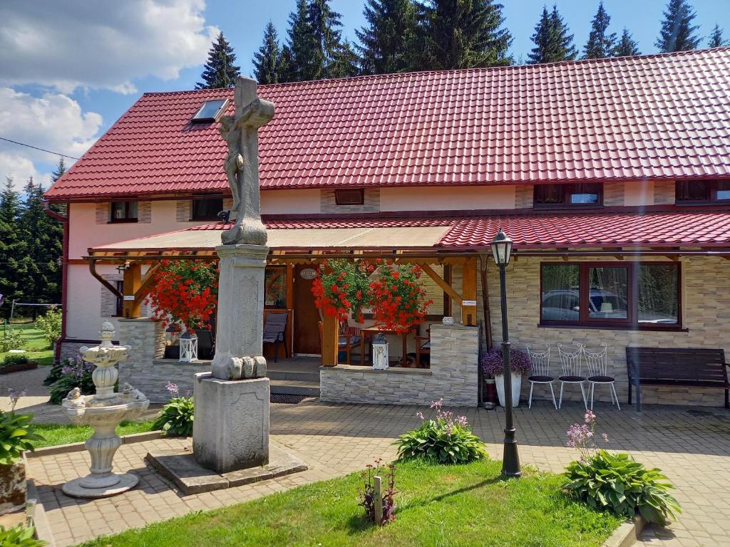 uma casa com uma estátua em frente em ZACISZE em Karłów