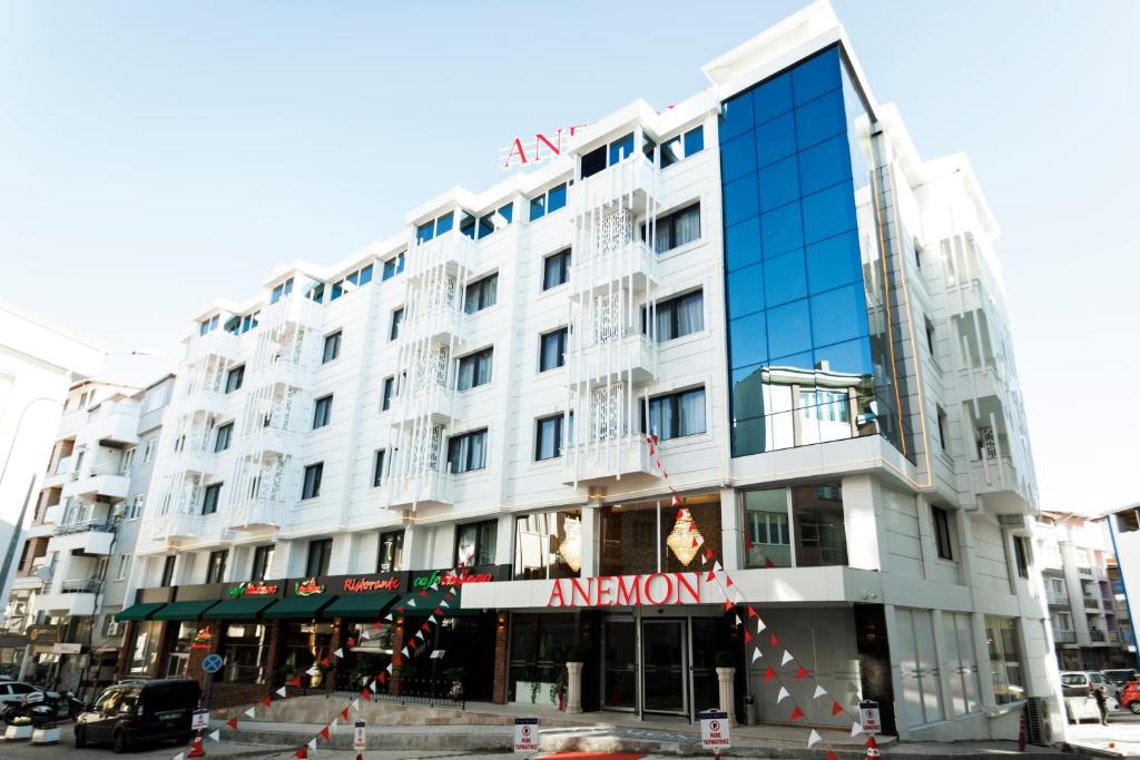 - un grand bâtiment blanc dans une rue de la ville dans l'établissement Anemon Uşak Hotel, à Uşak
