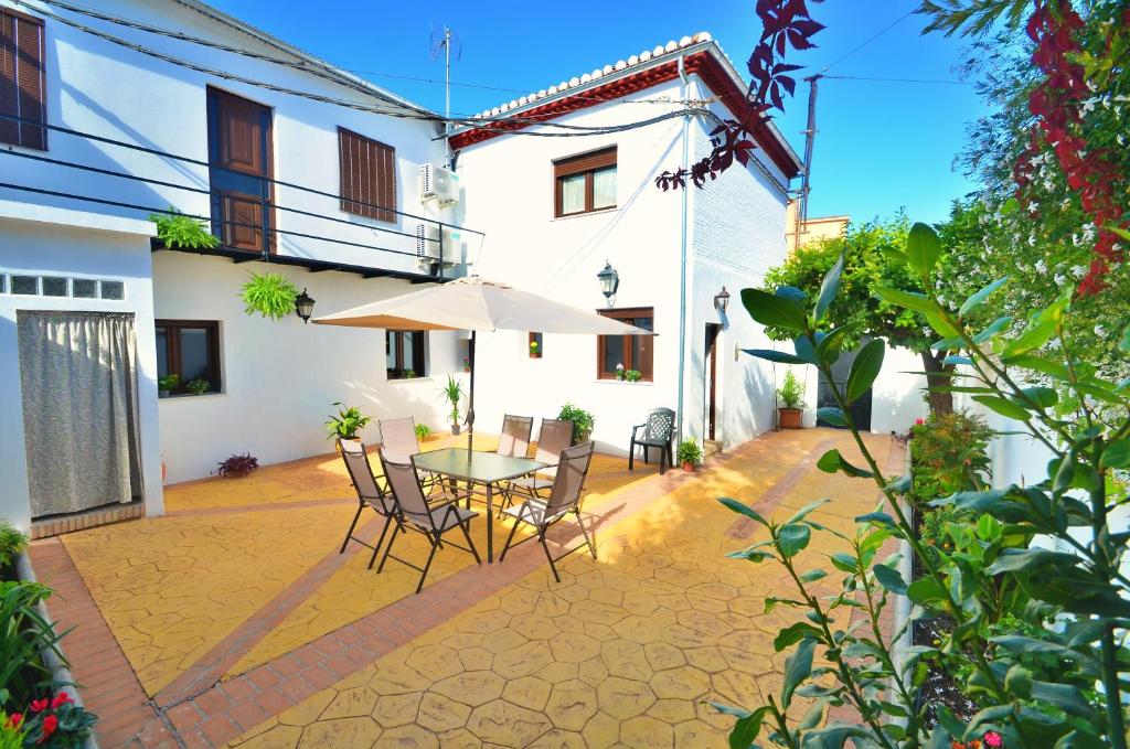 un patio con mesa, sillas y sombrilla en Casa Limon, Patio y Parking. en Granada
