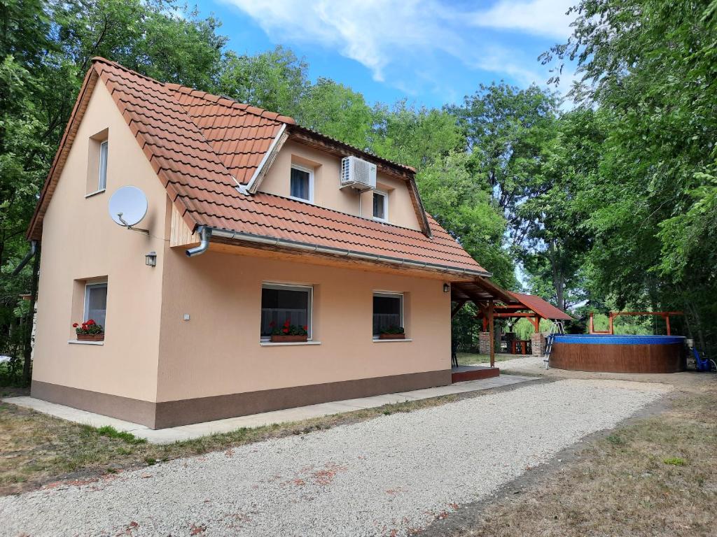 una pequeña casa con techo rojo en Panka Üdülőház-Bónom zug, en Gyomaendrőd