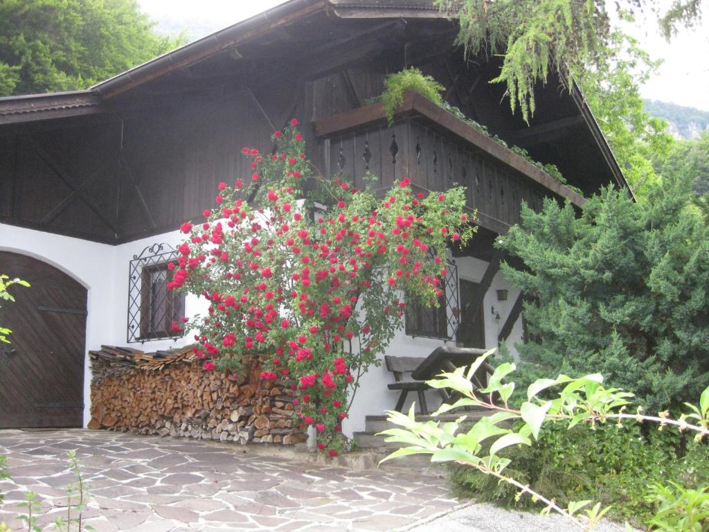 a building with red and white flowers on it at Haus Belluti Graun in Cortaccia