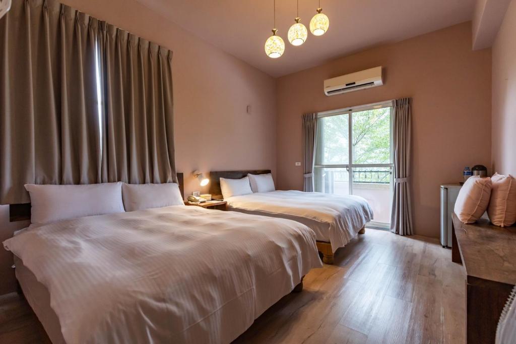 a hotel room with two beds and a window at Cloud Sun Homestay in Zhixue