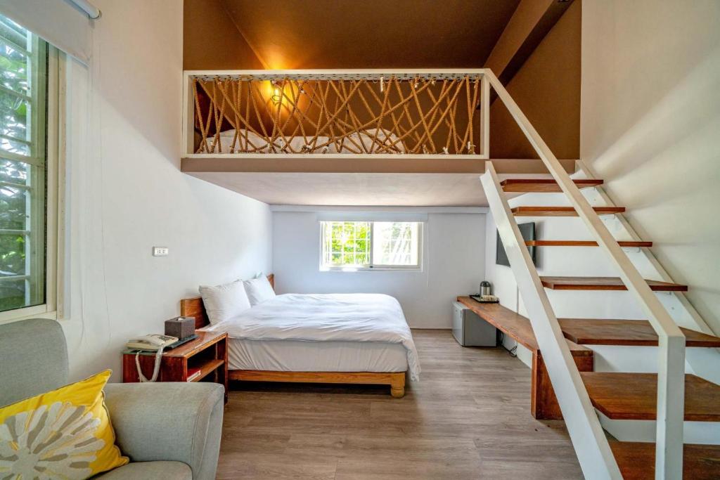 a small bedroom with a bed and a staircase at Cloud Sun Homestay in Zhixue