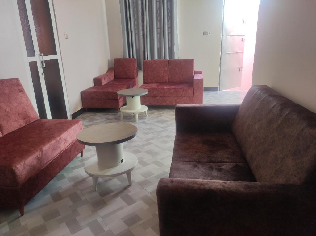 ein Wohnzimmer mit 3 Sofas und einem Tisch in der Unterkunft RS #10selous in Ukaranga