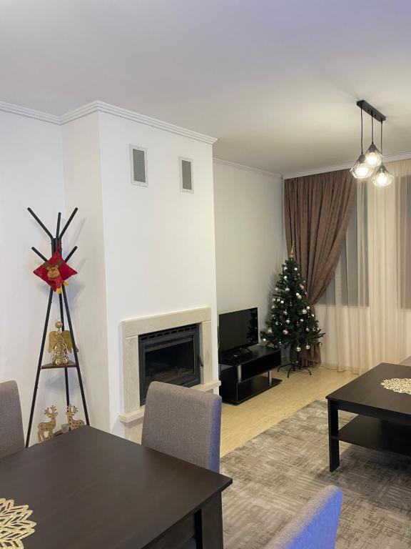 a living room with a christmas tree and a fireplace at Гранд Манастира , Пампорово in Pamporovo