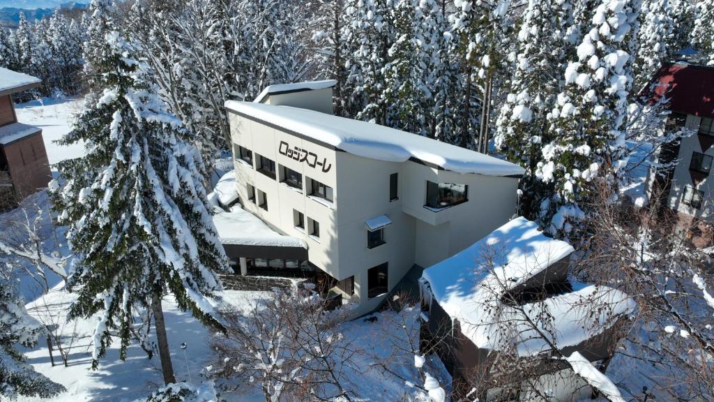 Un bâtiment dans la neige à côté de quelques arbres dans l'établissement Lodge Scole, à Zao Onsen